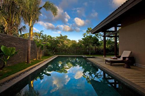 una piscina accanto a una casa con una villa di Narada Resort & Spa Perfume Bay Sanya - All Villas a Lingshui