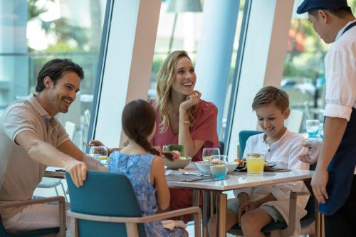 a family eating at a table in a restaurant at Jumeirah Beach Hotel in Dubai
