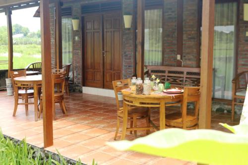 a patio with a table and chairs on a porch at Alamanda Family Villas, Pool & Local Tours in Yogyakarta