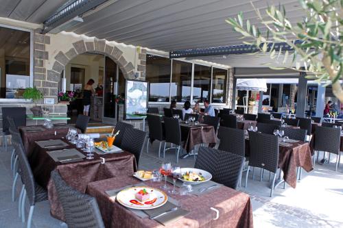 un restaurant avec des tables et des chaises avec de la nourriture dessus dans l'établissement Logis Hotel Restaurant le Mirador, à Portiragnes