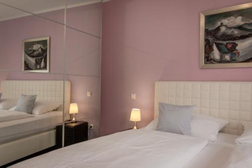 a bedroom with two beds with purple walls and two lamps at Ferienapartments Am Steinfelder Hof in Bad Neuenahr-Ahrweiler