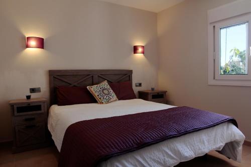 1 dormitorio con 1 cama con 2 luces en la pared en Canyamel 27, en Canyamel