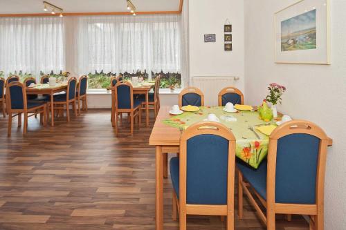 uma sala de jantar com mesas e cadeiras de madeira em Pension Haus Antje em Ahlbeck