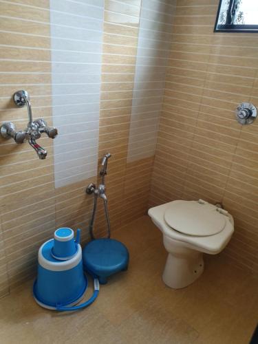 a bathroom with a toilet and a blue stool at Hotel Apex in Navi Mumbai