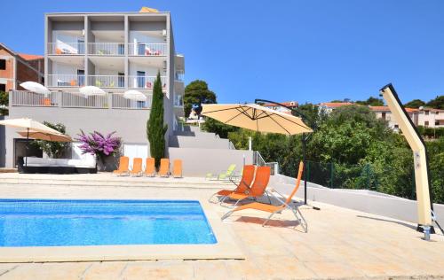 a pool with chairs and umbrellas and a building at Bretia Apartments in Sutivan