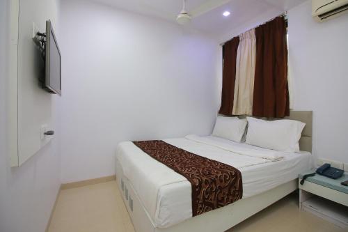 a bedroom with a bed and a television in it at Hotel Apex in Navi Mumbai