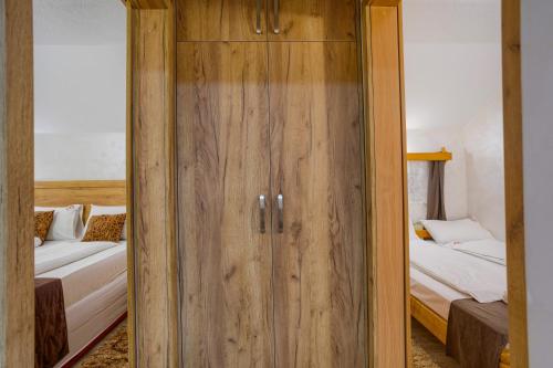 a wooden door in a room with two beds at Konačište Dabić in Zlatibor