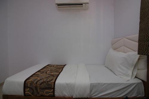a bedroom with a white bed with a pillow at Hotel Apex in Navi Mumbai