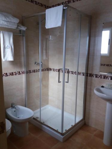 a bathroom with a shower and a toilet and a sink at La casa del viajero in Ardales