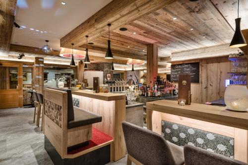 a bar in a restaurant with wooden walls at Hotel Zauchenseehof in Zauchensee