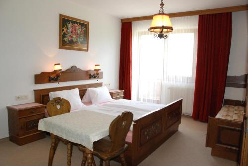 une chambre avec un lit, une table et une fenêtre dans l'établissement Paulingbauer, à Leogang