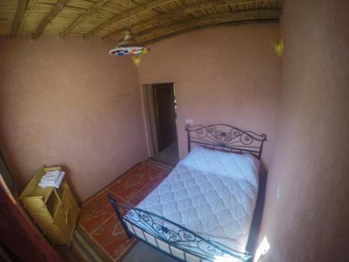 una camera con un letto nell'angolo di una stanza di iskki-asnfou a Tafraout