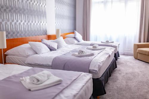 Habitación de hotel con 3 camas y toallas. en Budapest Griffin Guest House, en Budapest