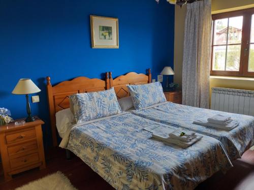 una camera blu con un letto con una parete blu di Posada Rural Entrecomillas a Comillas