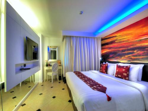 a hotel room with a bed and a painting on the wall at Aspira Skyy Sukhumvit 1 in Bangkok