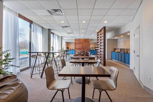 a cafeteria with tables and chairs and windows at The Capitol Hotel in Hartford
