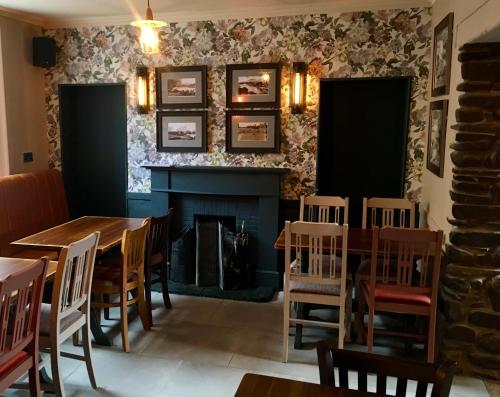 a dining room with a fireplace and a table and chairs at Kings Arms Hotel in Melrose