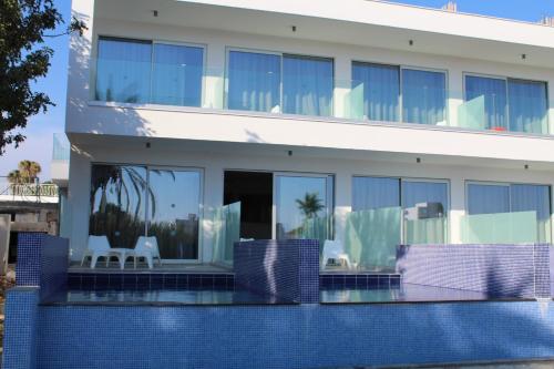 a house with a swimming pool in front of it at Fedrania Gardens Hotel in Ayia Napa