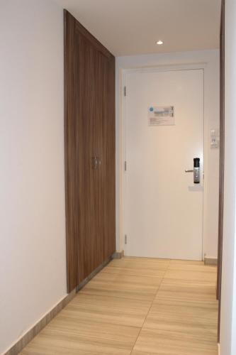 an empty room with a door and a wooden floor at Fedrania Gardens Hotel in Ayia Napa