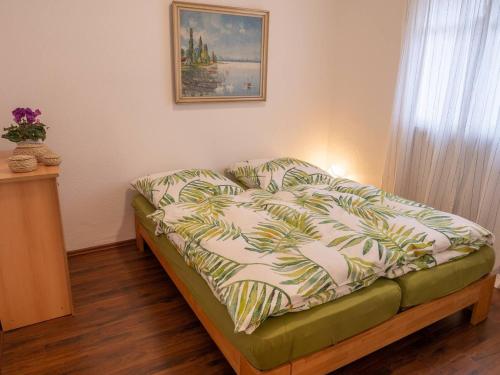 a bed with a comforter on it in a room at Messe-Apartment in Essen