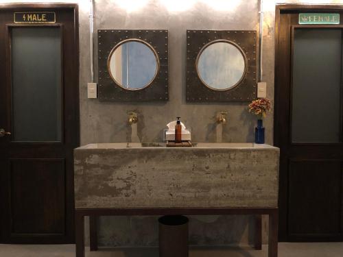 a bathroom with two sinks and two mirrors at Goodnight Poshtel + Free Netflix in Hat Yai