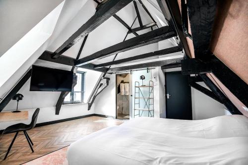 een slaapkamer met een wit bed en een stoel bij Boutique hotel WKNDS in Leeuwarden