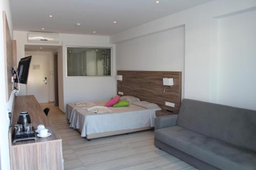 a hotel room with a bed and a couch at Fedrania Gardens Hotel in Ayia Napa