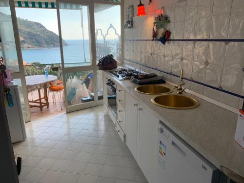 a kitchen with two sinks and a view of the ocean at Casa Formis in Levanto