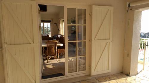 an open door to a dining room with a table at Les Myrtes in Les Issambres