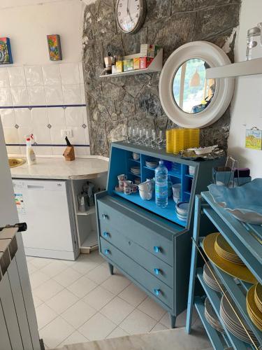 ein blauer Schrank in einer Küche mit einem Spiegel in der Unterkunft Casa Formis in Levanto