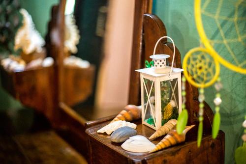 a wooden table with a stand with shells and a small lantern at Cozy Dream Apartment in Anjuna