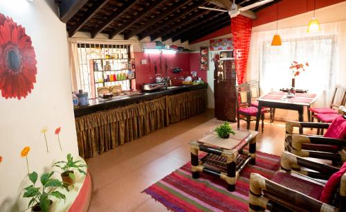 a living room with red walls and a kitchen at Cozy Dream Apartment in Anjuna