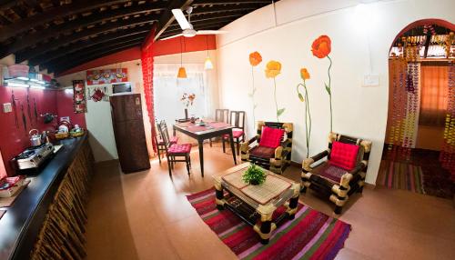 a living room with a dining table and chairs at Cozy Dream Apartment in Anjuna