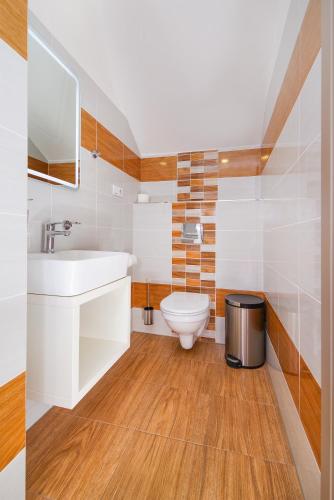 a bathroom with a white sink and a toilet at Penzion Lesni in Milovice