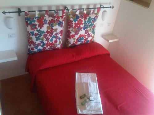 a bedroom with a red bed with a plastic bag on it at Casa Falcone B&B in Scala