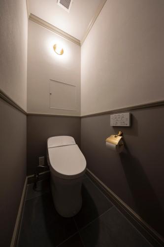 a small bathroom with a toilet and a light at UNWIND HOTEL & BAR OTARU in Otaru