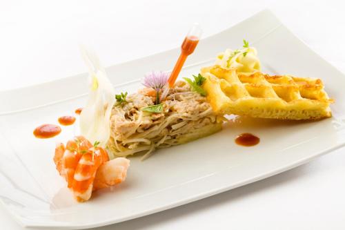 a plate of food with waffles and shrimp at Hotel-restaurant Les Caudalies in Arbois