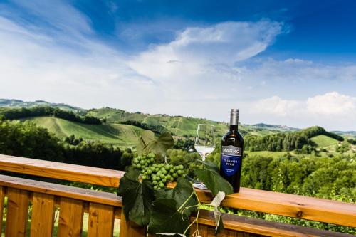 a bottle of wine and a glass on a wooden railing at Weingut- Gästezimmer Marko in Leutschach