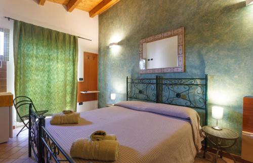 a bedroom with a large bed and a mirror at Agriturismo Il Gelsomino Ritrovato in Milazzo