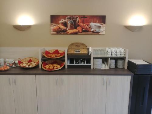 a counter with bowls of food on top at Logis Hotel Altina in Pacy-sur-Eure