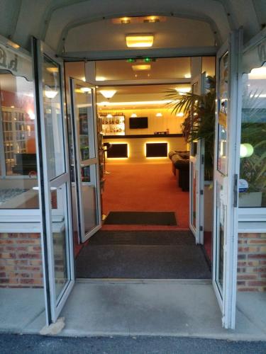 an open door to a room with a living room at Logis Hotel Altina in Pacy-sur-Eure