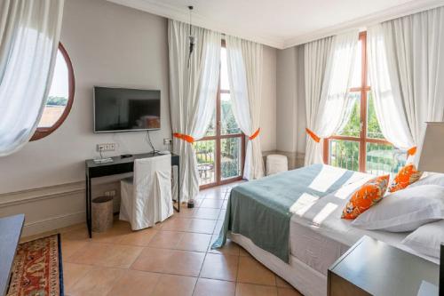 a bedroom with a bed and a tv and windows at Casa Anamaria Hotel in Ollers