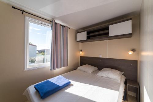 une chambre avec un grand lit avec une fenêtre dans l'établissement borddemer hôtellerie de plein air, à Saint-Michel-Chef-Chef