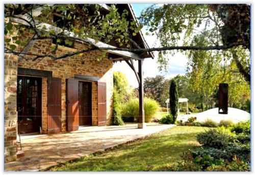 a brick house with a door in a yard at Le Fuchier in Saint-Martin-de-Fressengeas