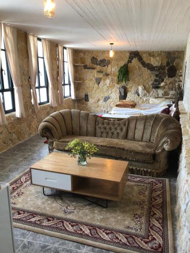 a living room with a couch and a table at Zimer Al-Bayt in Mas'ade