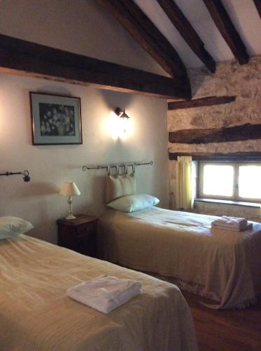 a bedroom with two beds and a window at L'écurie Gite in Saint-Pierre-de-Côle