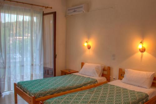 a bedroom with two beds and a window at Salvanos Residence in Ipsos