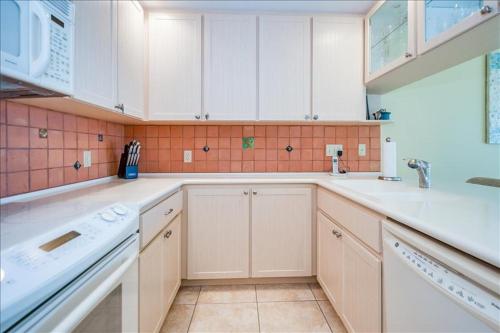 a kitchen with white cabinets and a sink at Sea Oats 336 Condo in Boca Grande