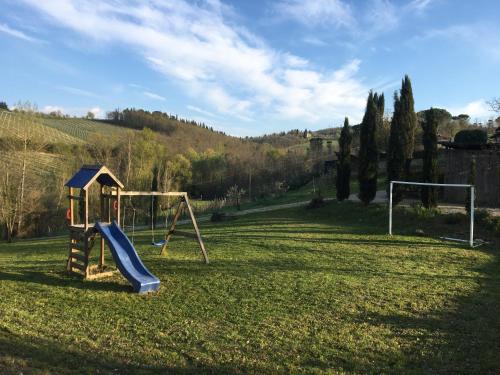 a playground with a slide in a field at Il Vichiaccio Country House in Impruneta