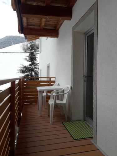 a wooden deck with a table and chairs on a balcony at Hofstatthof in Campo di Trens